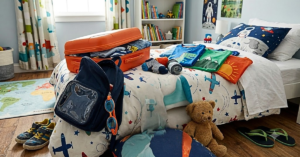 A child's bedroom with an open suitcase and a summer travel documents for kids